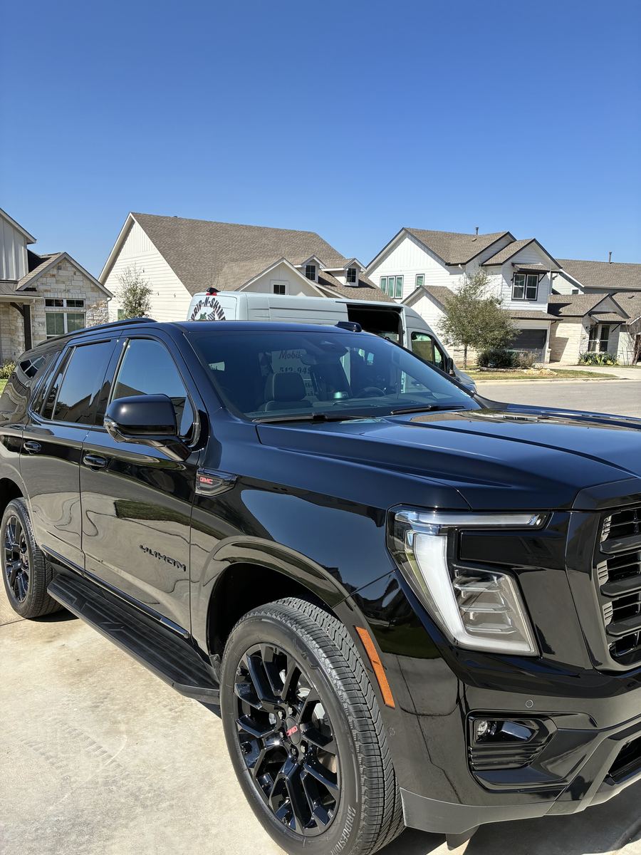 Black Cadillac Escalade hand washed and gleaming in a Dripping Springs neighborhood