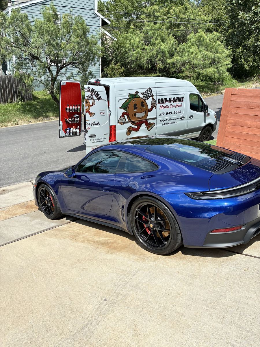 The Drip-N-Shine van parked beside a freshly washed blue Porsche 911
